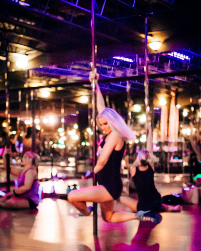 Blonde woman swinging on a pole at her birthday party
