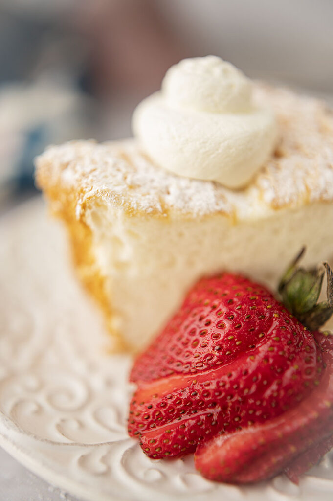 a slice of angel food cake with fresh strawberries and whipped cream