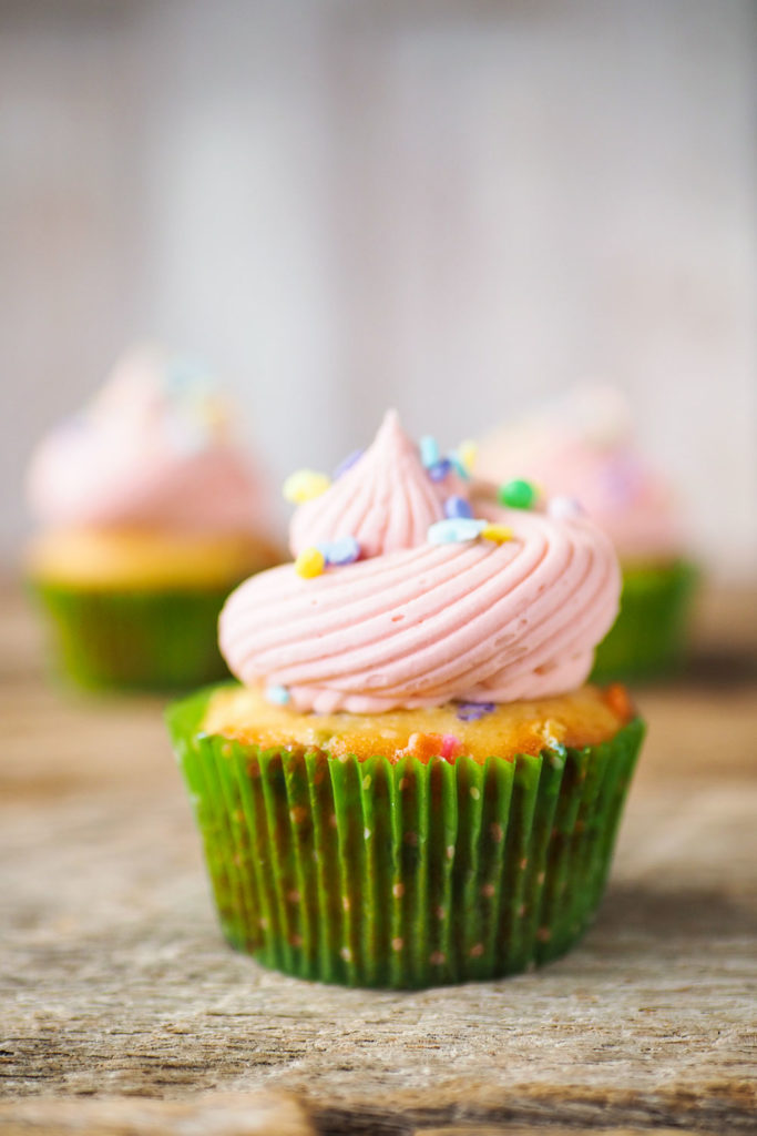 grouping of cupcakes with pink frosting