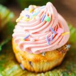funfetti cupcake with wrapper peeled away and pink frosting