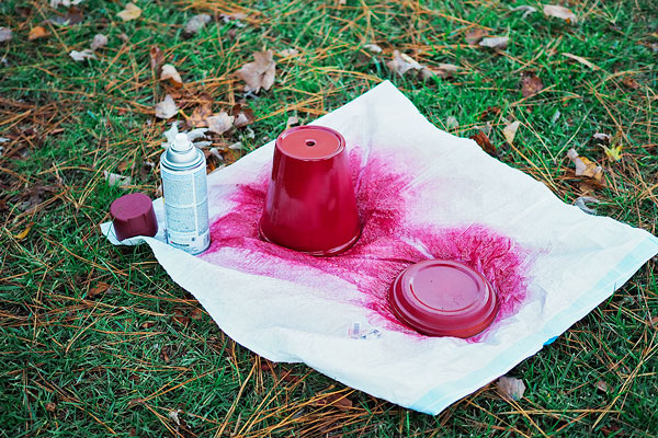 terra cotta pot in the process of being spray painted red