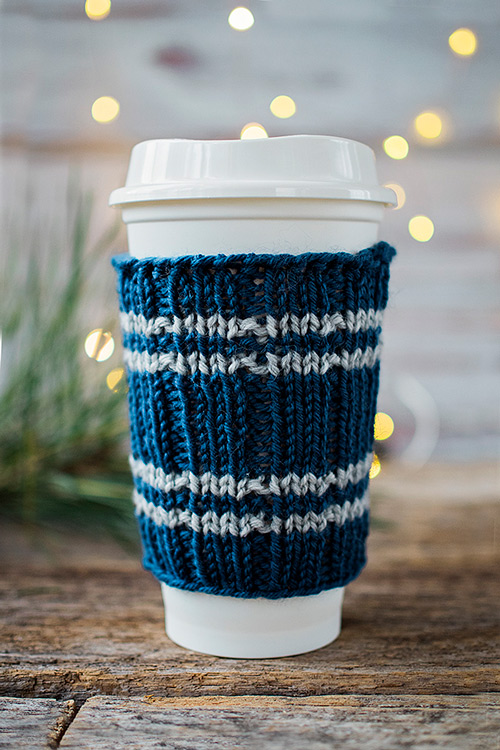 close up of travel cup fitted with a knitted sleeve