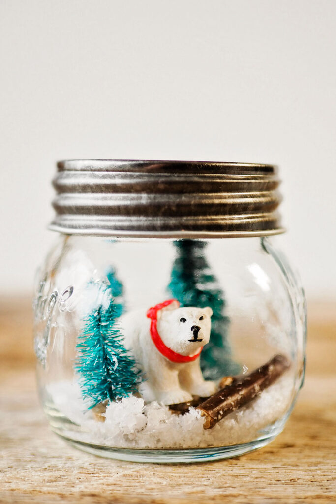 waterless snow globe with a polar bear, bottle brush trees and fake snow.