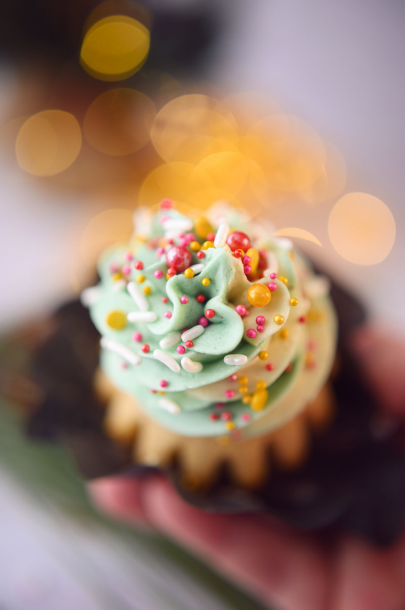 very close up, overhead view of the beautiful light green frosting swirled on a vanilla cupcake