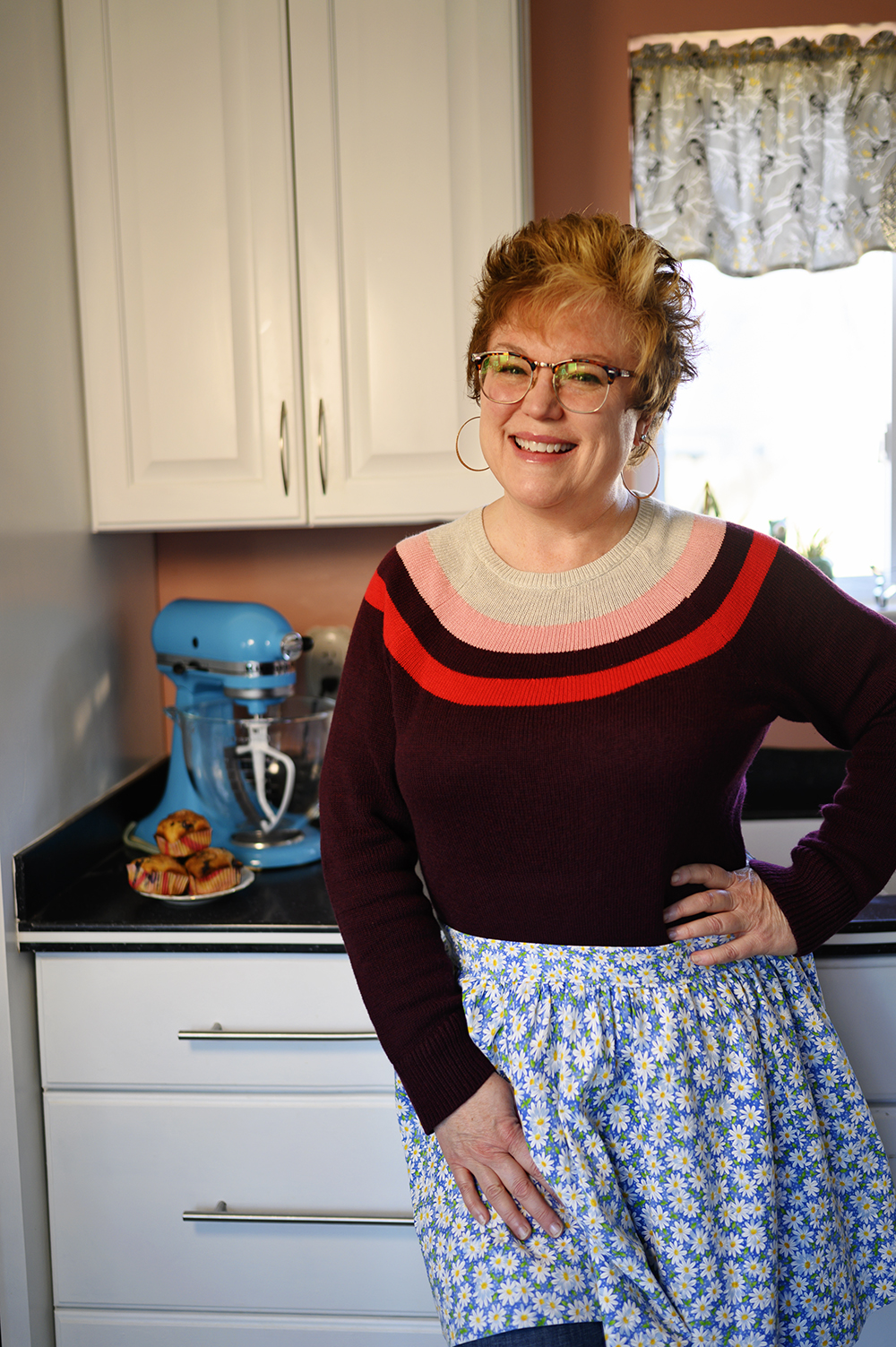 smiling woman wearing an apron in a home kitchen