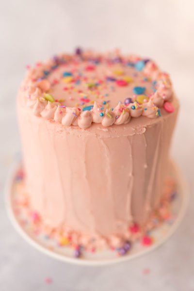 top of decorated cake with pink frosting and sprinkles