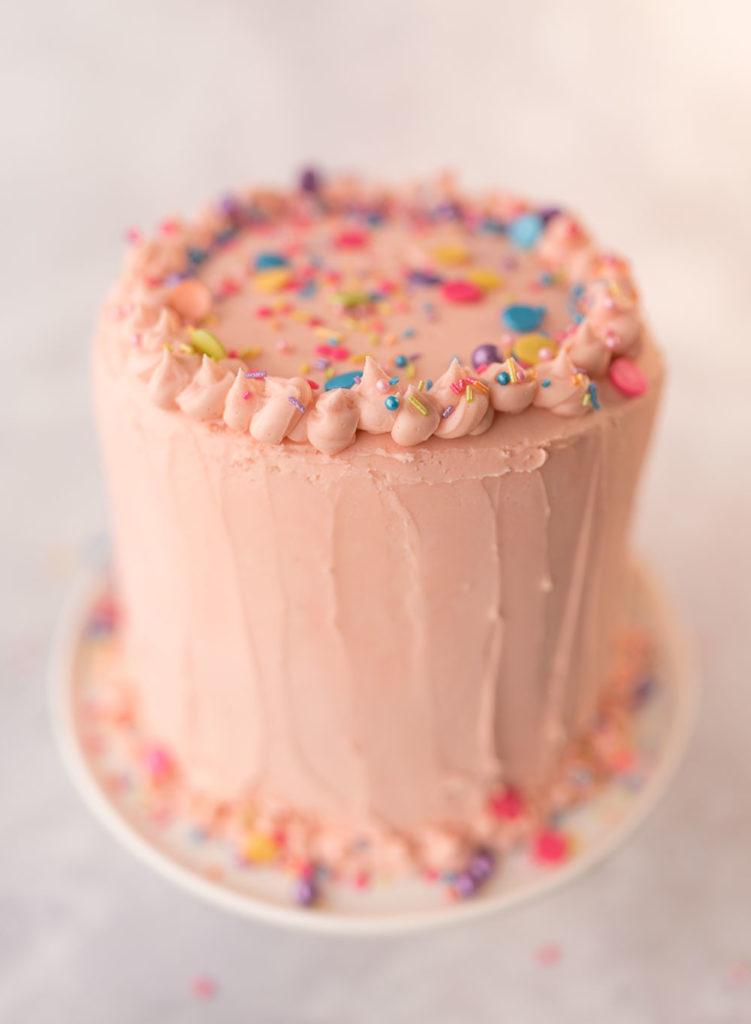 top of decorated cake with pink frosting and sprinkles