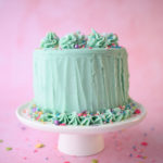 pretty layer cake with mint green frosting and colorful sprinkles