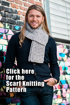 stylish young man demonstrates a wrapped scarf around his neck posing in from of a street art mural