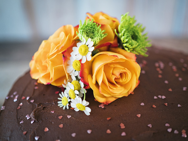 closeup of the roses and daisies floral arrangement made to decorate the chocolate cake