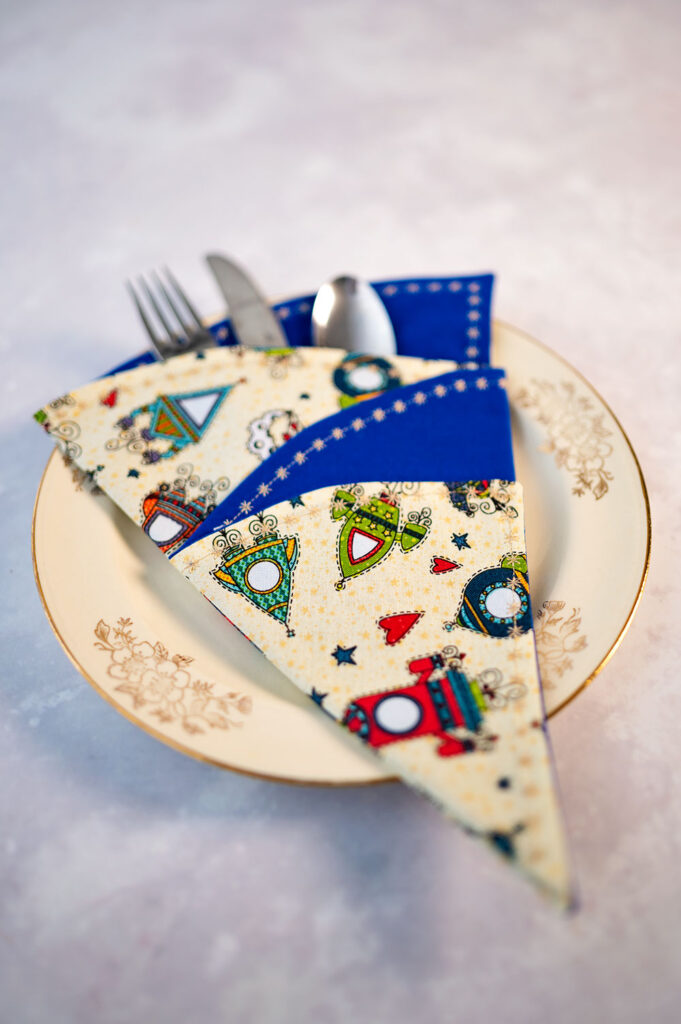 Christmas tree napkin styled as a place setting on a vintage dessert plate