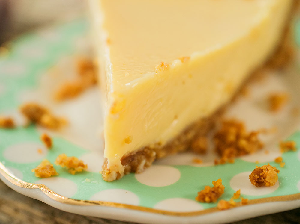 Closeup of the pointed wedge of a slice of pie showing how beautifully this lemon pie keeps its shape when cut