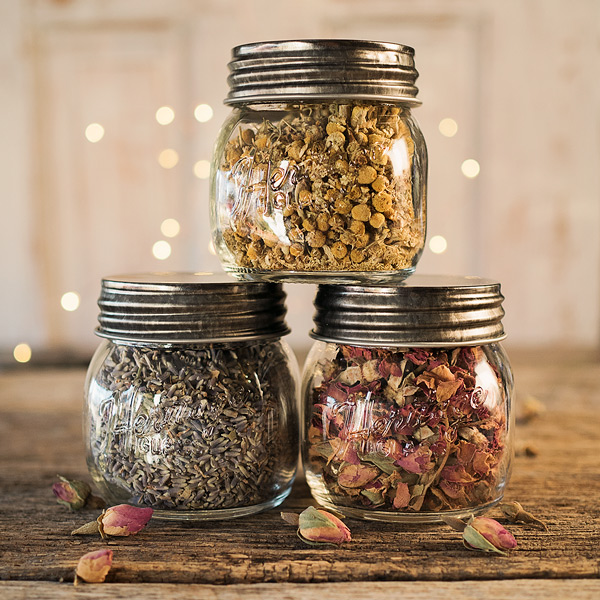 three jars filled with dried herbs