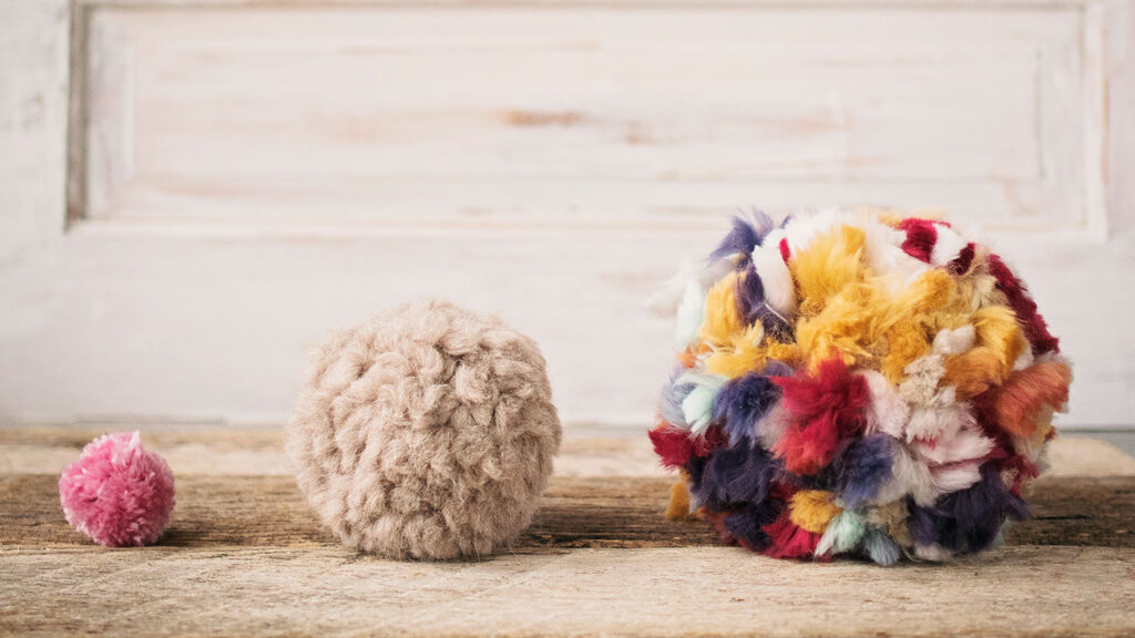 3 pom poms are lined up from smallest to largest