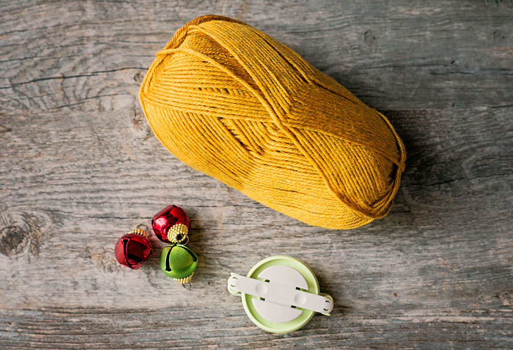 golden yellow yarn with a medium pom pom maker