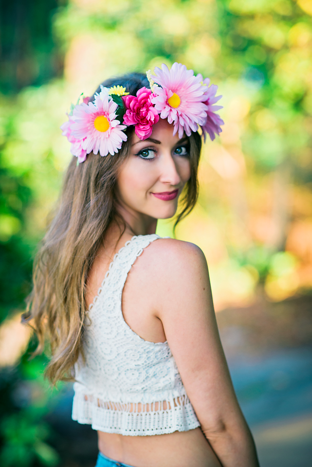model shows off vibrant pink flower crown while looking over her shoulder