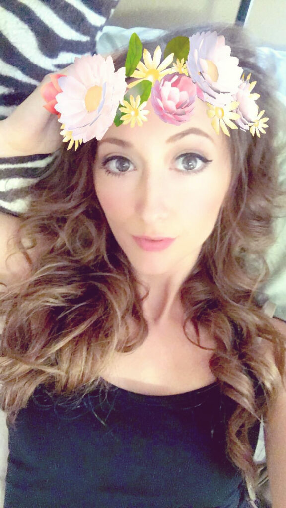 pretty girl in a snap chat filter image with a flower crown filter.