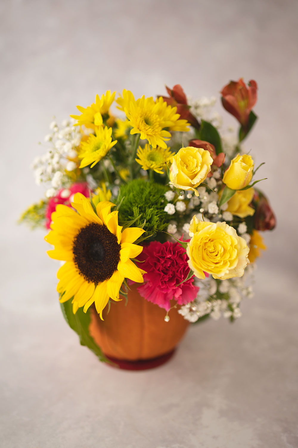 closeup of mostly yellow fresh cut flowers in a fall floral arrangement