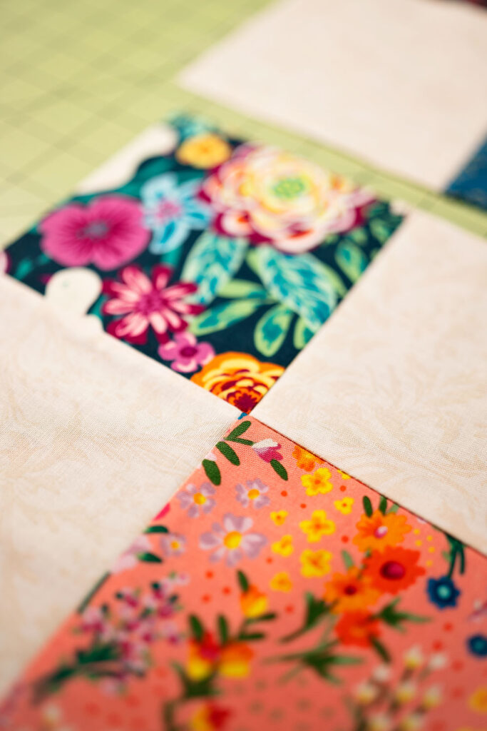 two colorful fabrics meet at a corner point in a quilt block