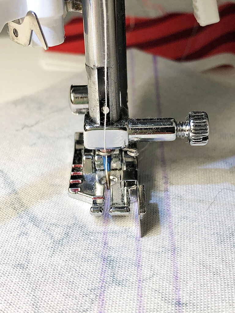 close up of sewing machine needle following a drawn line to indicate the stitching line
