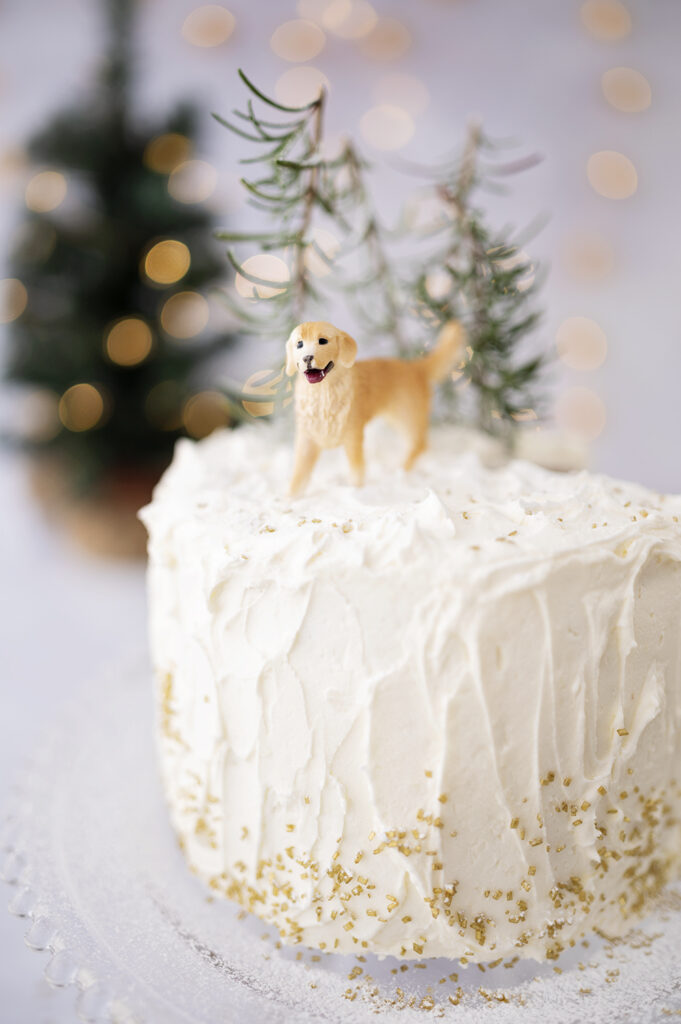 White cake with golden retriever miniature on top for a decoration