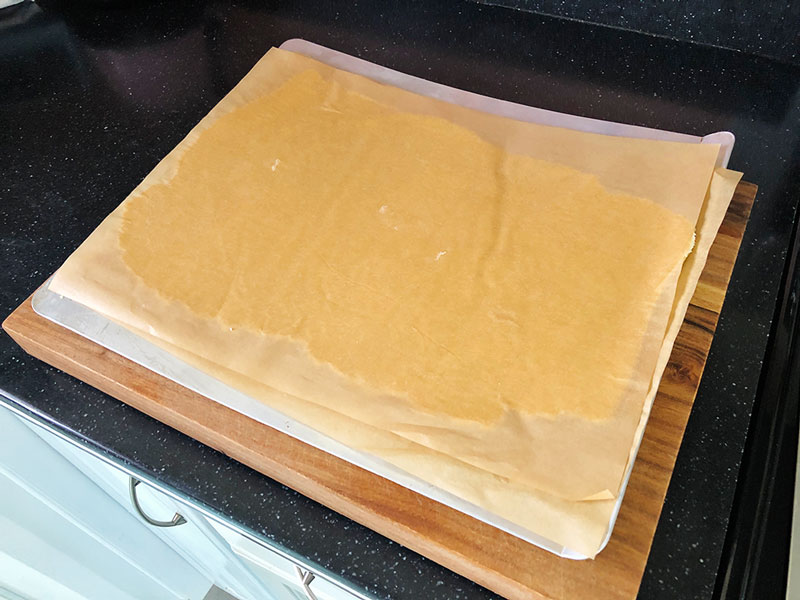 rolled sugar cookie dough between sheets of parchment