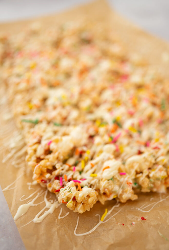 close up of a corner piece of fancy rice krispies treats topped with white chocolate and sprinkles