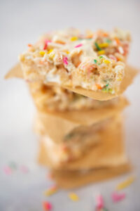 close up of a stack of cut rice krispies treats with colorful sprinkles