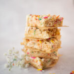 close up of a stack of cut rice krispies treats with colorful sprinkles