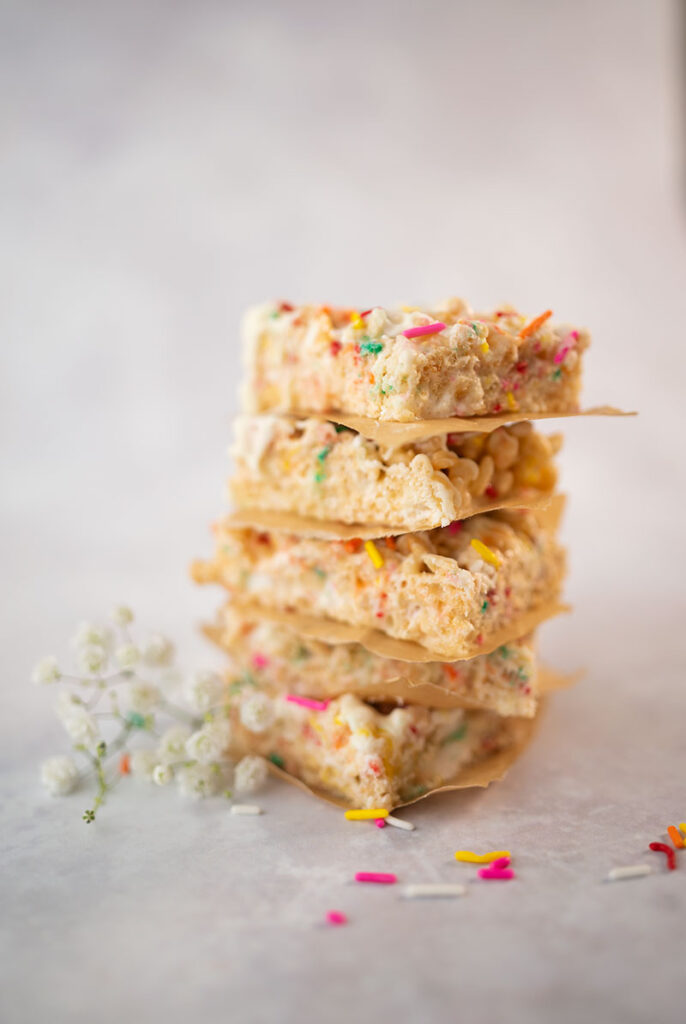 close up of a stack of cut rice krispies treats with colorful sprinkles
