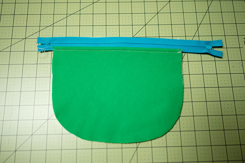 One half of zipper pouch panels are sewn to the zipper and top stitched. We are looking at the lining side of the project.