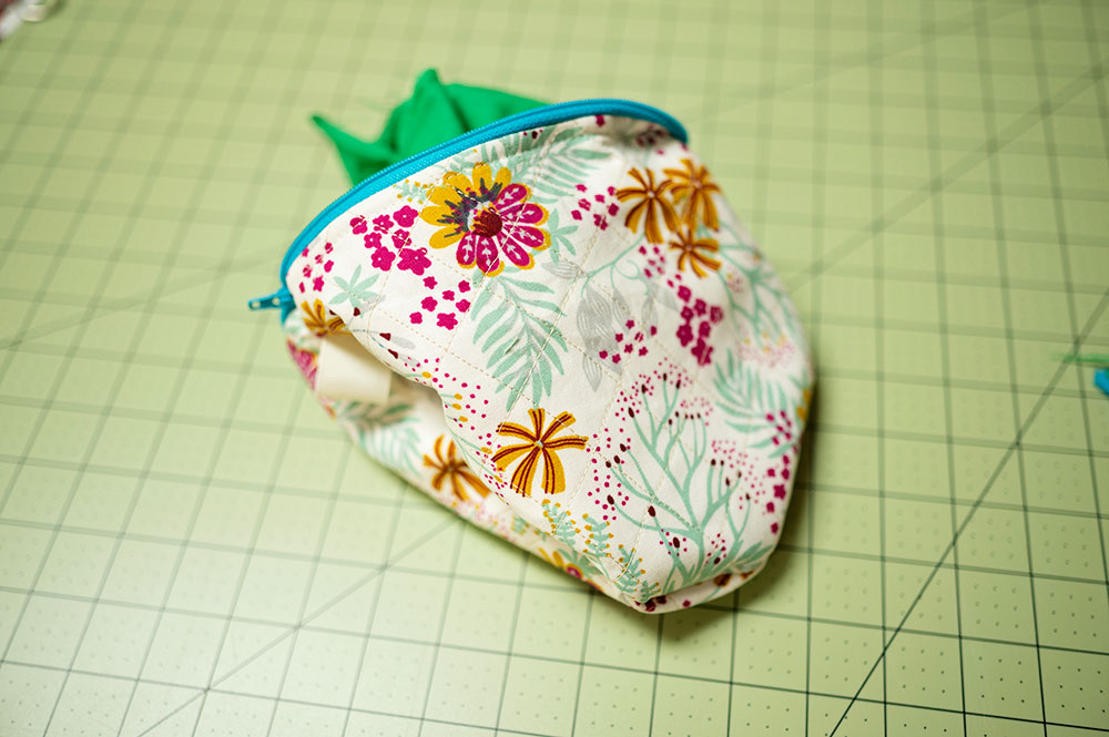 Quilted zipper pouch is turned inside out, but needs to have the seams opened up and bag pressed flat