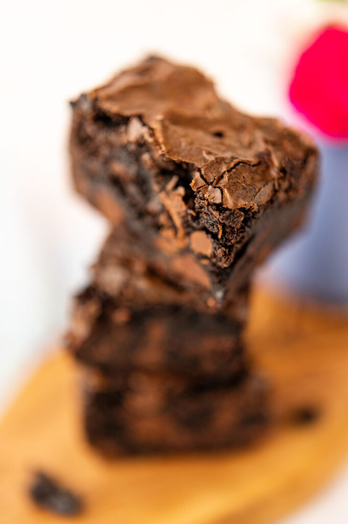 close up view of a stack of brownies showing the shiny crust on top