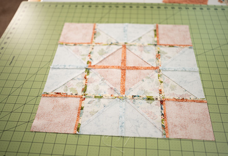 the wrong side of a large quilt block showing the pressed seams