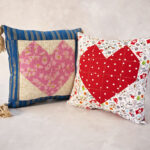 two colorful pillows with a large heart emblem on each