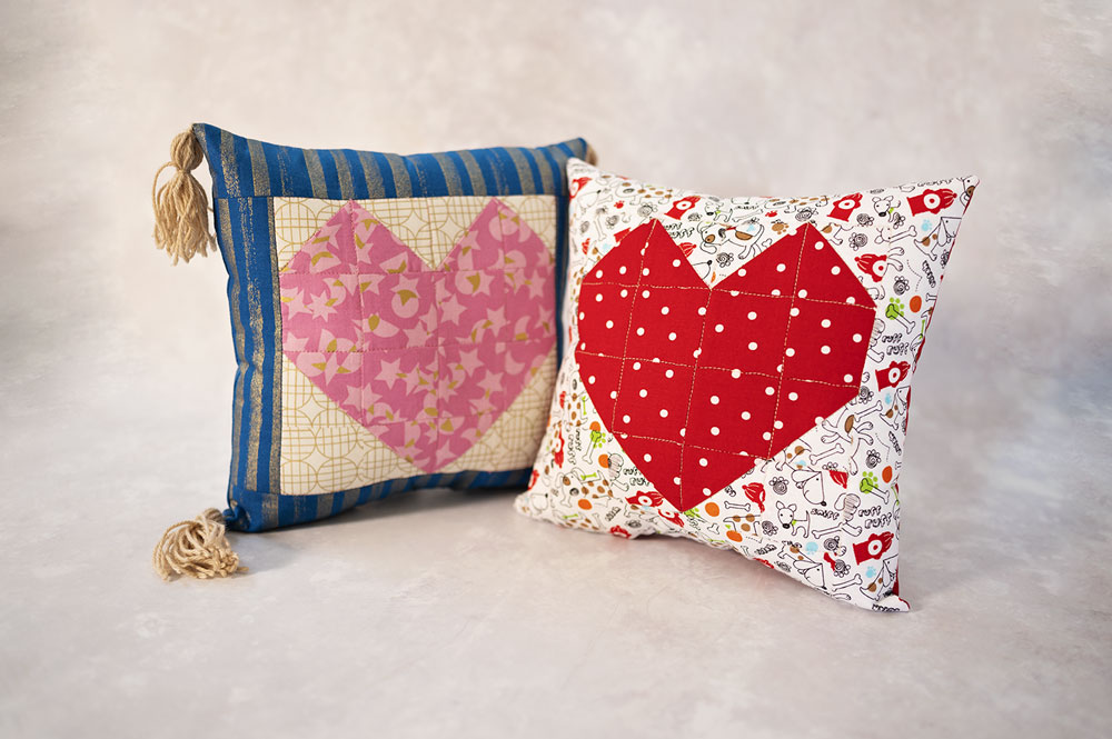 two colorful pillows with a large heart emblem on each