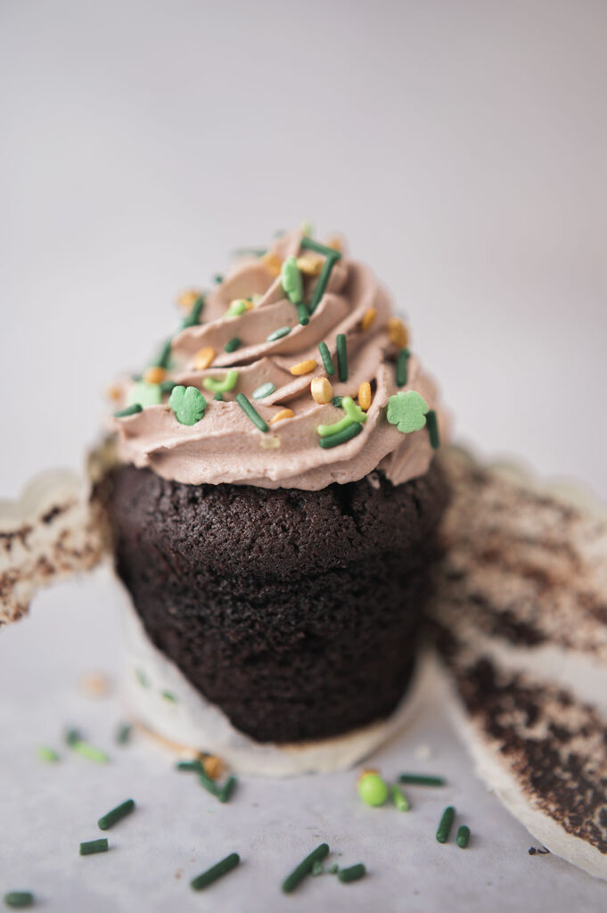 chocolate cupcake with the wrapper peeled away revealing the cake