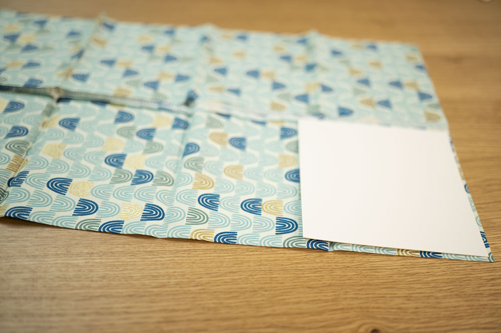 piece of fabric with a square piece of card stock in the lower right corner