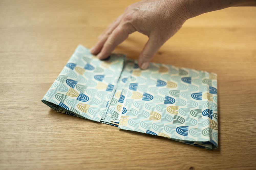 a hand folds fabric