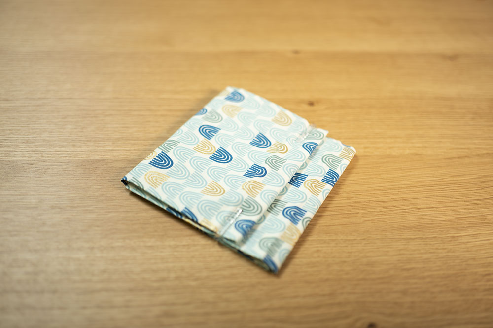 a folded piece of fabric with blue rainbows secured with plastic clips