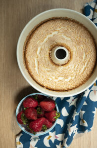 overhead picture of angel food cake in a pan with strawberries