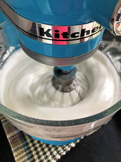 a blue mixer mixing a white cake