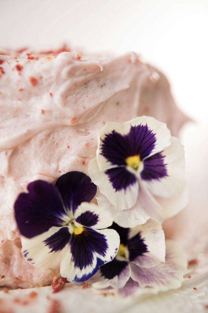 close up of petunias on a pink cake