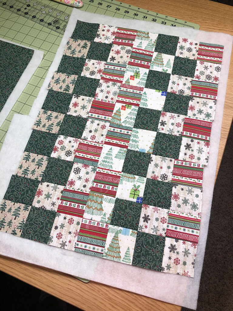 patchwork fabric adhered to quilt batting