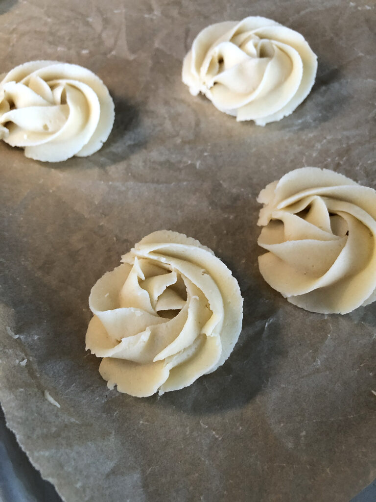 piped cookie dough in the shape of rosettes