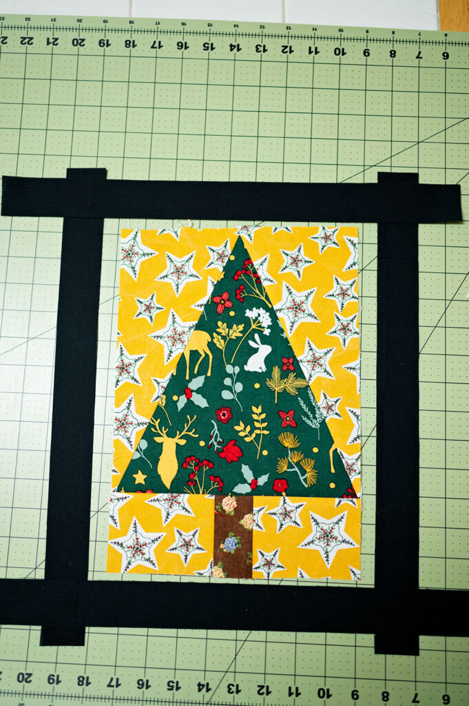 strips of black fabric frame a tree block