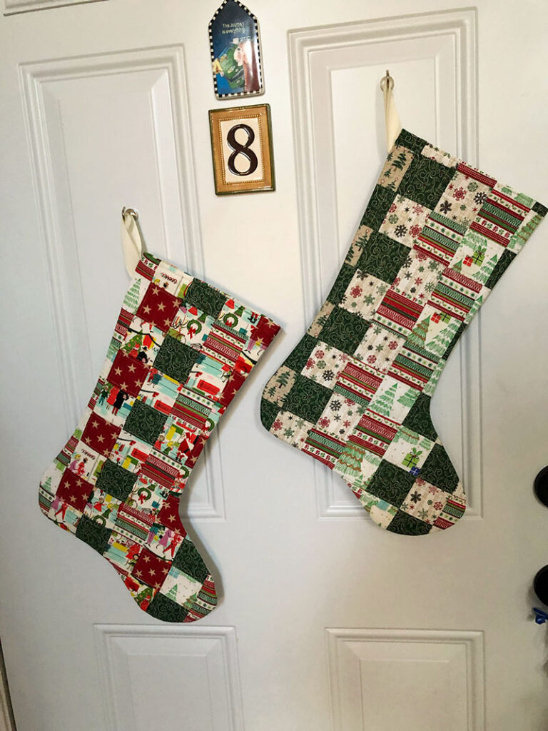 two christmas stockings hanging on a door