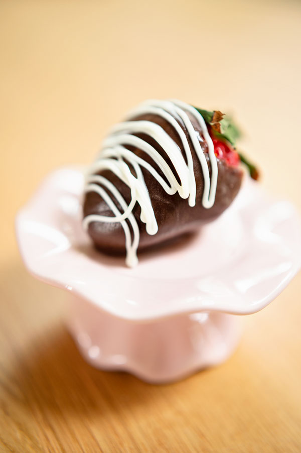 chocolate covered strawberry on a small pedestal