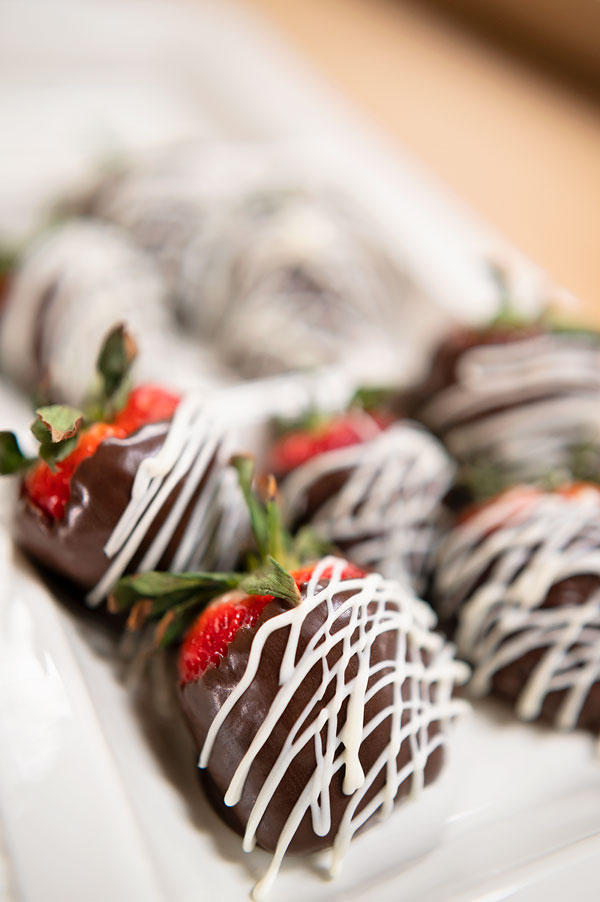 a white tray full of chocolate dipped strawberries