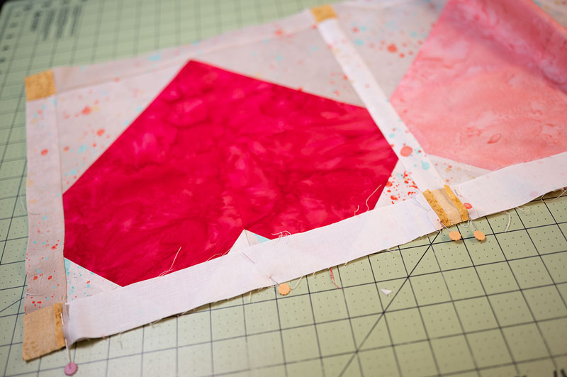 close up showing how to pin the seams of the joyful hearts table runner